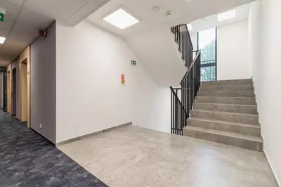 an empty hallway with stairs in a building at Cozy Studio Apartments Sauna & AC Kraków by Noclegi Renters in Kraków