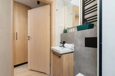 a bathroom with a sink and a mirror at Cozy Studio Apartments Sauna & AC Kraków by Noclegi Renters in Kraków