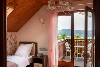 a bedroom with a bed and a balcony at Dom z Widokiem Mucharz 405 in Mucharz
