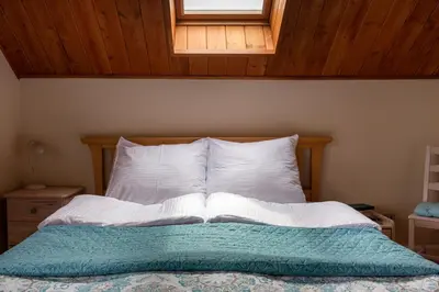 a bedroom with a bed with white pillows and a window at Dom z Widokiem Mucharz 405 in Mucharz