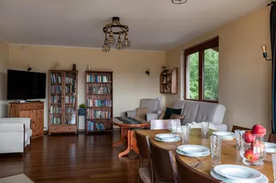 a living room with a table and chairs and a couch at Dom z Widokiem Mucharz 405 in Mucharz