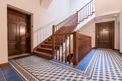 a hallway with stairs and blue tiled floor at Cadena Gallery Apartments Mehoffer in Kraków