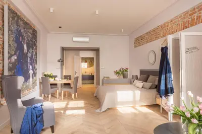 a bedroom with a bed and a dining room at Cadena Gallery Apartments Mehoffer in Kraków