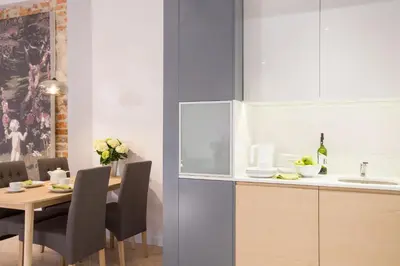 a kitchen and dining room with a table and a sink at Cadena Gallery Apartments Mehoffer in Kraków