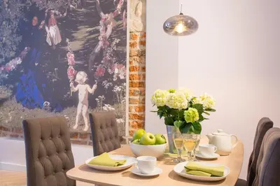 a dining room table with a vase of fruit and flowers at Cadena Gallery Apartments Mehoffer in Kraków