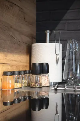 a shelf with glass jars and a roll of paper towels at Premium Apartment Eleven in Zator