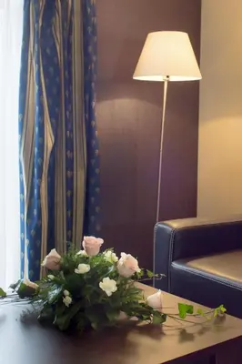 a vase of flowers on a table in a hotel room at Hotel Novum & Spa in Niepołomice
