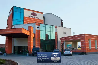 a building with a car parked in front of it at Hotel Novum & Spa in Niepołomice