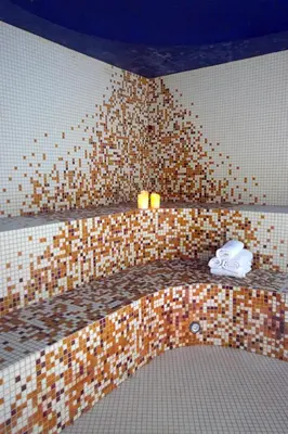a bathroom with a tiled wall with two toilets at Hotel Novum & Spa in Niepołomice