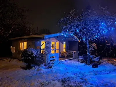 a tiny house with blue lights on it at night at Leśny zakątek malediwy Jacuzzi free in Jaworzno