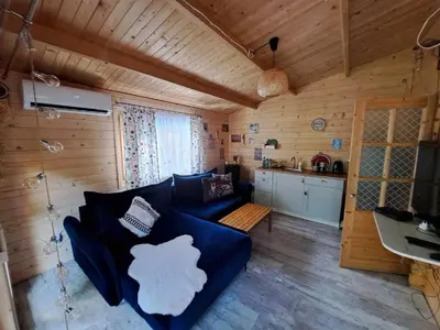 a living room with a blue couch and a kitchen at Leśny zakątek malediwy Jacuzzi free in Jaworzno