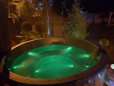 a jacuzzi tub in a backyard at night at Leśny zakątek malediwy Jacuzzi free in Jaworzno