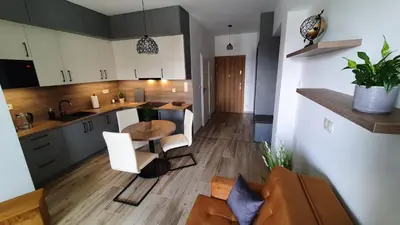 a kitchen and living room with a table and chairs at Apartament 20 Zator in Zator
