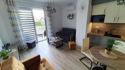 a kitchen and living room with a table and a couch at Apartament 20 Zator in Zator