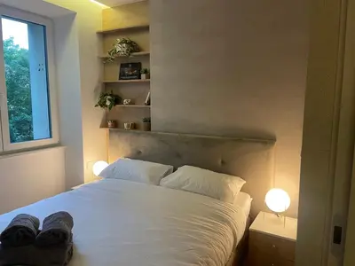 a bedroom with a white bed with two shoes on it at CRYSTAL CAVE Apartment in Wieliczka