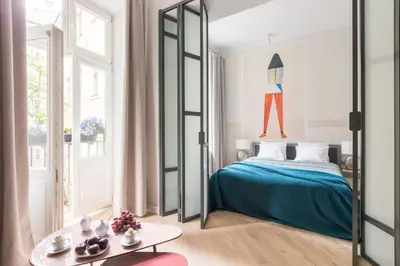 a bedroom with a bed with a blue blanket at Cadena Gallery Apartments Witkacy in Kraków