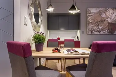 a dining room with a wooden table and purple chairs at Cadena Gallery Apartments Witkacy in Kraków