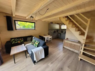 a living room with a couch and a staircase at Widokówka in Zawoja