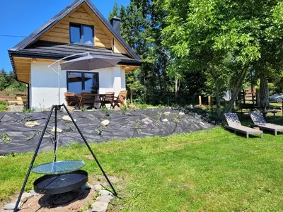 a camera in the grass in front of a house at Widokówka in Zawoja