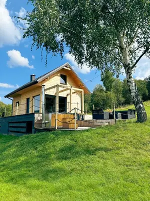 a house in a field with a tree at Duchałówka 2.0 in Koszarawa