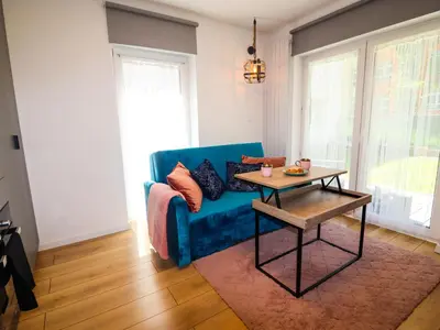 a living room with a blue couch and a table at Sander Apartments in Kraków