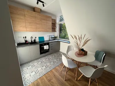 a kitchen with a table and chairs in a room at Apartament Willa Bellevue in Rabka