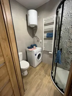 a small bathroom with a toilet and a washing machine at Apartament Willa Bellevue in Rabka