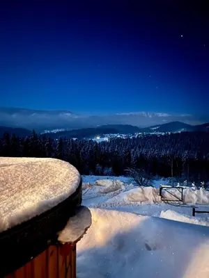 a snow covered balcony with a view of the mountains at Ovis Homes in Zawoja