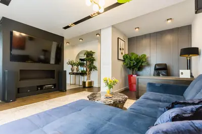 a living room with a blue couch and a tv at Luxury penthouse with jacuzzi in Kraków