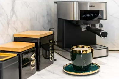 a coffee maker and a cup on a counter at Luxury penthouse with jacuzzi in Kraków