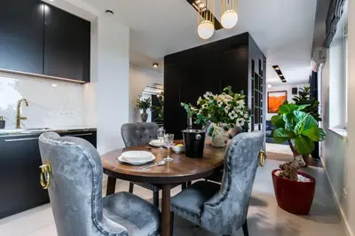 a dining room with a wooden table and blue chairs at Luxury penthouse with jacuzzi in Kraków