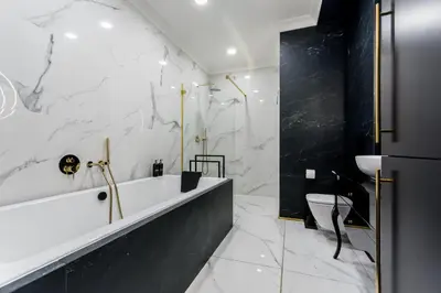a white bathroom with a tub and a toilet at Luxury penthouse with jacuzzi in Kraków