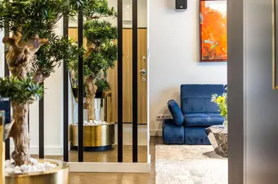 a living room with a blue couch and trees at Luxury penthouse with jacuzzi in Kraków