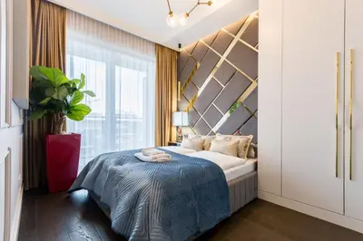 a bedroom with a bed and a large window at Luxury penthouse with jacuzzi in Kraków
