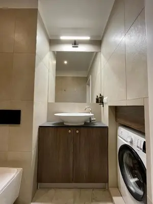 a bathroom with a sink and a washing machine at Golden Queen Apartments City Center in Kraków