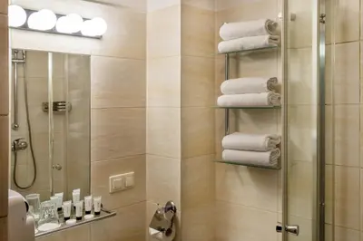 a bathroom with a shower and some towels at David Boutique ApartHotel in Kraków