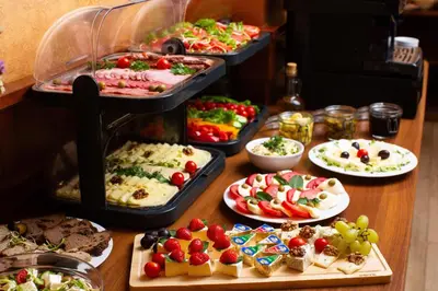 a table topped with different types of food on plates at David Boutique ApartHotel in Kraków