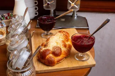a cutting board with a pastry and two glasses of sauce at David Boutique ApartHotel in Kraków