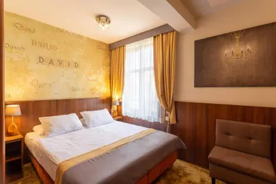a hotel room with a bed and a chair at David Boutique ApartHotel in Kraków