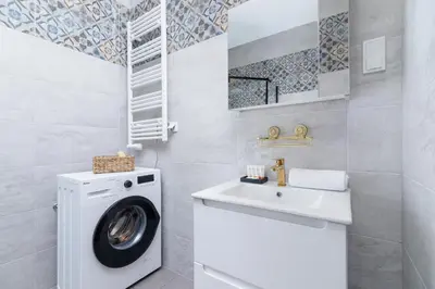 a bathroom with a washing machine and a sink at Fabryczna City Kraków by Renters by Noclegi Renters in Kraków