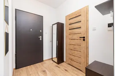 a hallway with a black door and a wooden closet at Fabryczna City Kraków by Renters by Noclegi Renters in Kraków