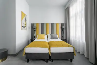 a bedroom with a bed with a yellow blanket at Old Town Residence Aparthotel in Kraków