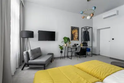 a bedroom with a bed and a chair and a table at Old Town Residence Aparthotel in Kraków