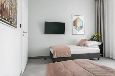 a hotel room with two beds and a flat screen tv at Old Town Residence Aparthotel in Kraków