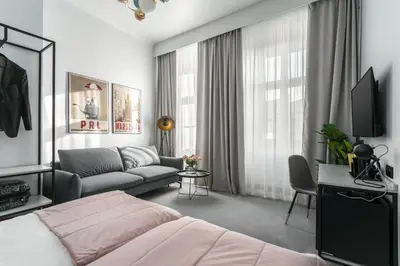 a bedroom with a bed and a couch and a tv at Old Town Residence Aparthotel in Kraków