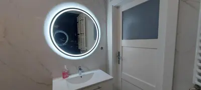 a bathroom with a sink and a mirror at Apartament BARCELONA in Kraków