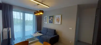 a living room with a blue couch and a window at Apartament BARCELONA in Kraków