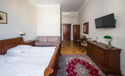 a bedroom with a bed and a flat screen tv at Aparthotel Basztowa in Kraków