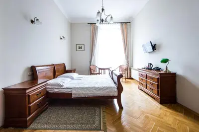 a bedroom with a bed and a dresser and a window at Aparthotel Basztowa in Kraków