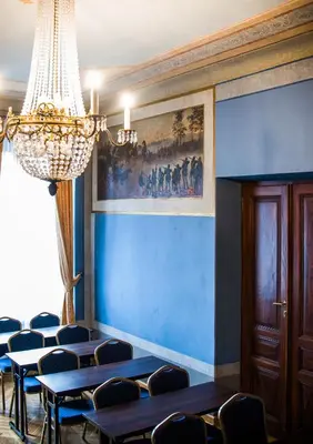 a room with blue walls and chairs and a chandelier at Aparthotel Basztowa in Kraków